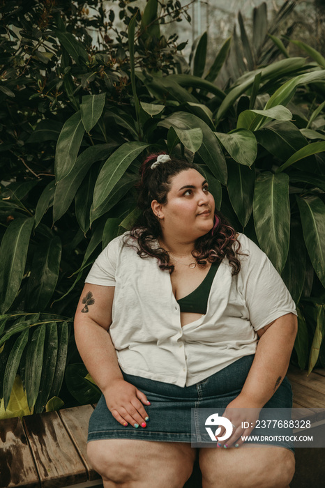 portrait of a plus size woman surrounded by tropical plants