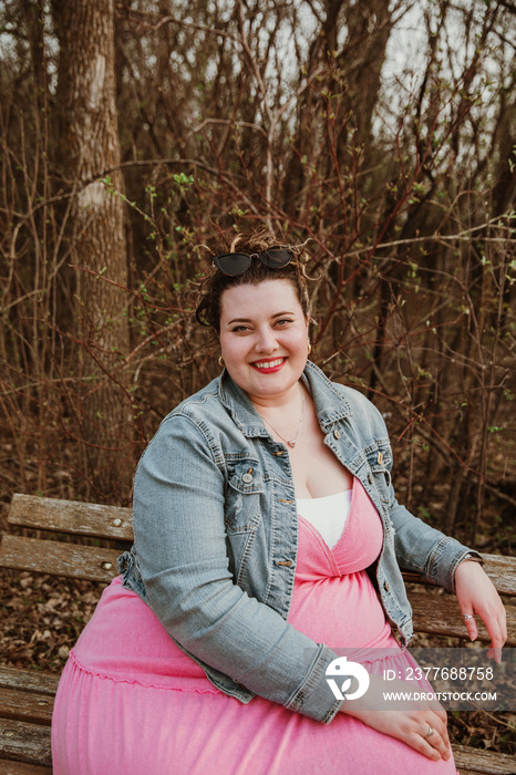 portrait of a plus size woman wearing a pink dress outside