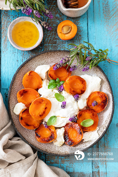 Grilled apricots with buratta cheese , granola and honey. Summer breakfast