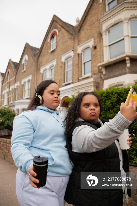 Two curvy women with Down Syndrome taking selfies in with their coffees