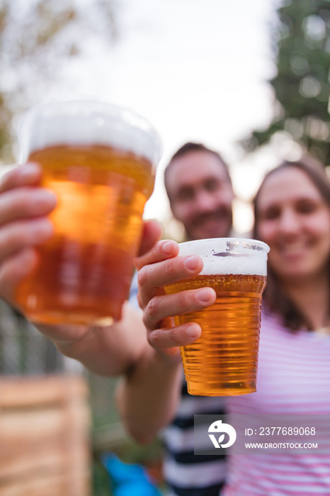 Friends enjoying drinking beer in the backyard.