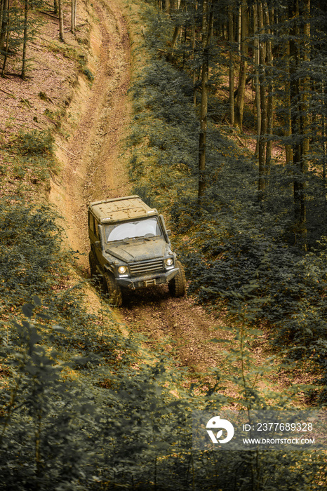 Off-road vehicle goes on mountain way. Mud and water splash in off the road racing. Motion the wheels tires and off-road that goes in the dust on the sand.