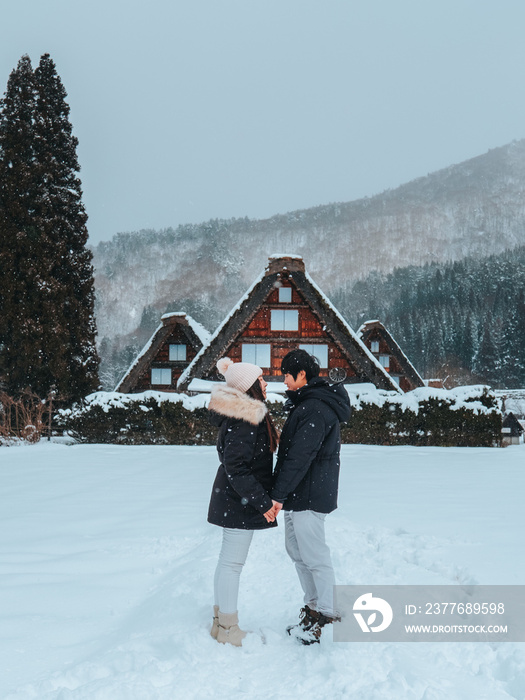 Asian Couple tourist travelling  Shirakawago village with white snow, Japan  Winter Season