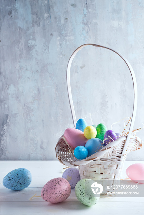 Easter basket filled with colorful hand painted Easter Eggs over a light background