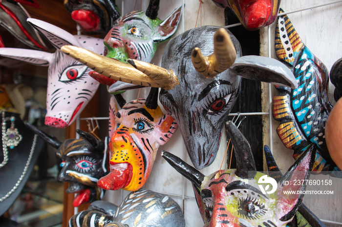 traditional mexican mask adornment, angels and demons pottery colorful carnival masks in a market in Puebla city, Mexico