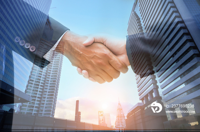 ฺฺฺBusiness men shaking hands as a background image of a building in the city center to work together to do business colleague Achieve business goals,successful  and the growth of business .