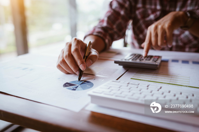 Businessman working on calculator to calculate business data the financial report. Business financial analysis and strategy concept.