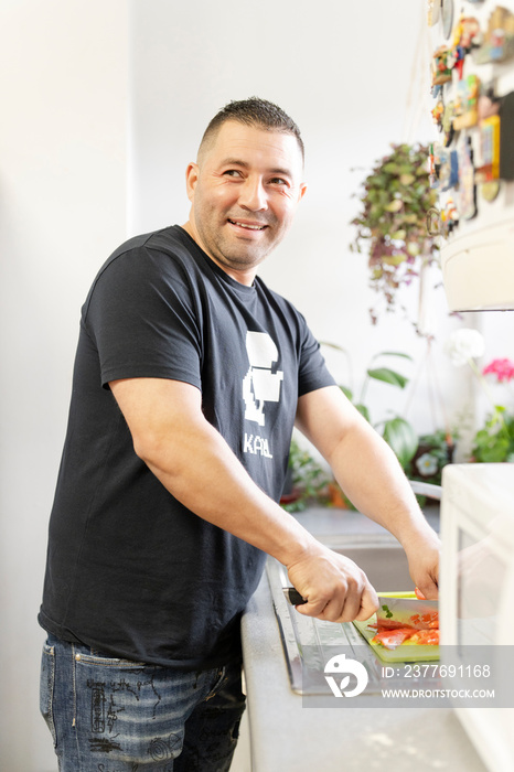 Portrait of man preparing food in kitchen