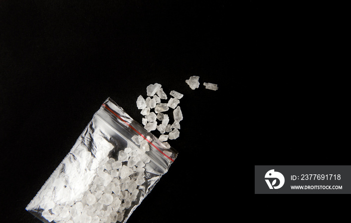 Conceptual image of  bath salts  synthetic cathinones drugs narcotics concept. White crystal powder on black background( set up), resemble to bathroom bath salt.