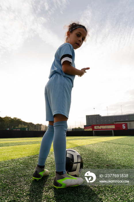 Girl (6-7) playing soccer on soccer field