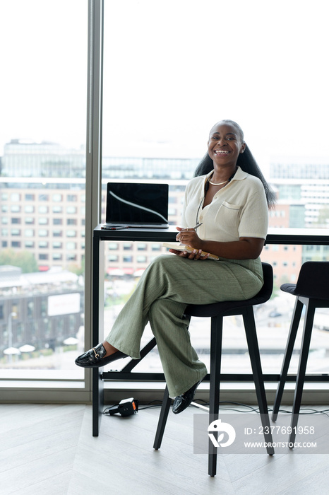 Businesswoman with laptop working in modern office