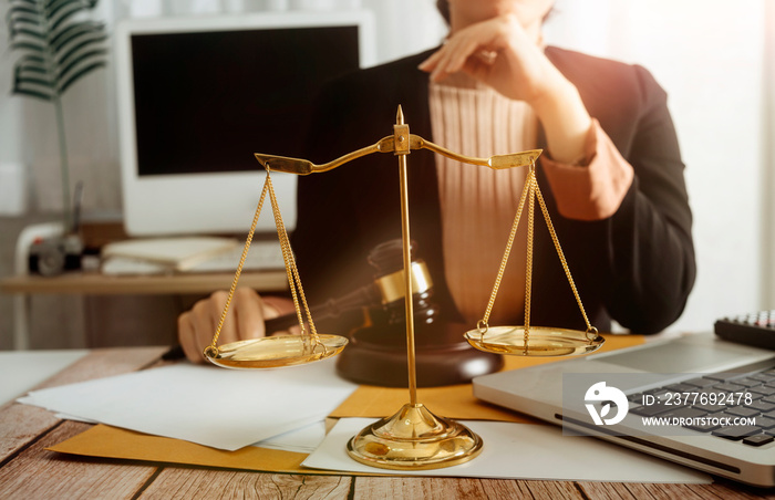 Business and lawyers discussing contract papers with brass scale on desk in office. Law, legal services, advice, justice and law concept picture with film grain effect