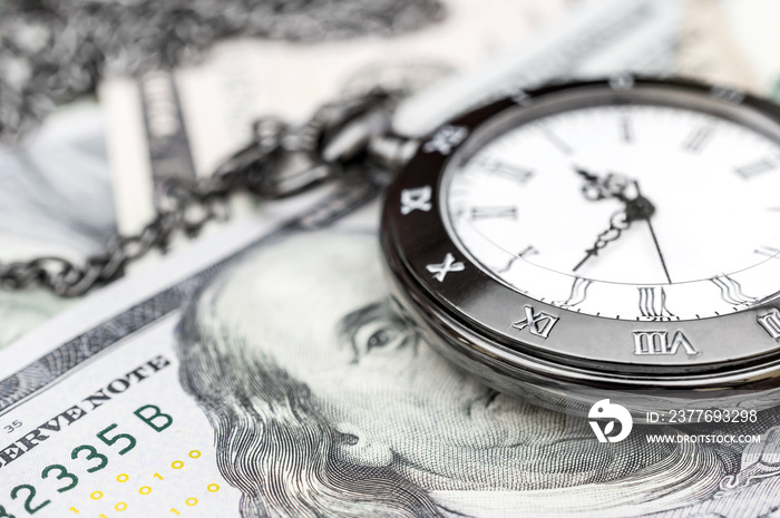 Pocket watch on dollar bills. Close up.