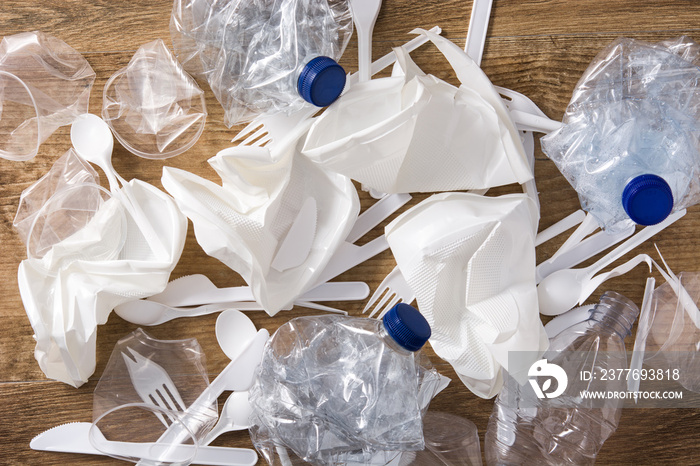 Disposable waste plastic on wooden background.  Top view