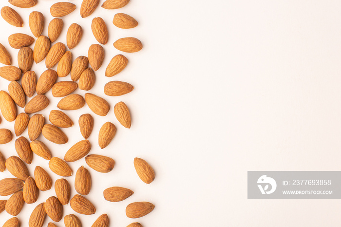 Almond pattern on beige background, top view with copy space