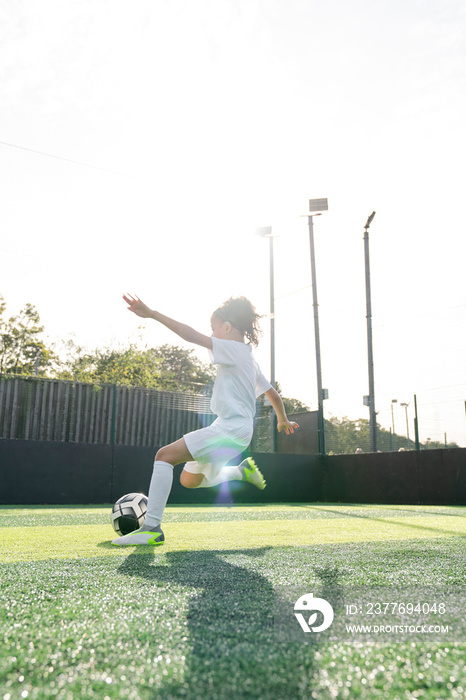 Girl (6-7) playing soccer on soccer field