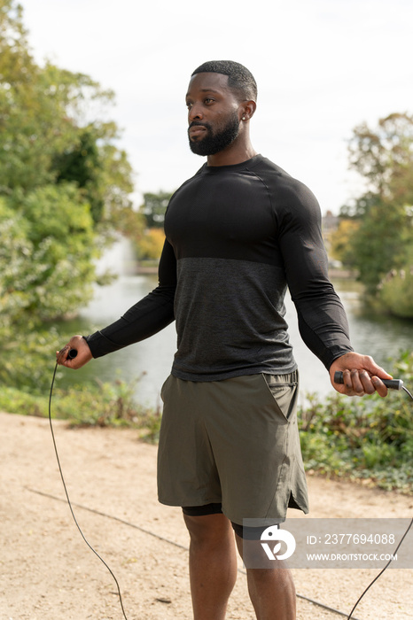 Athletic man with jump rope in park