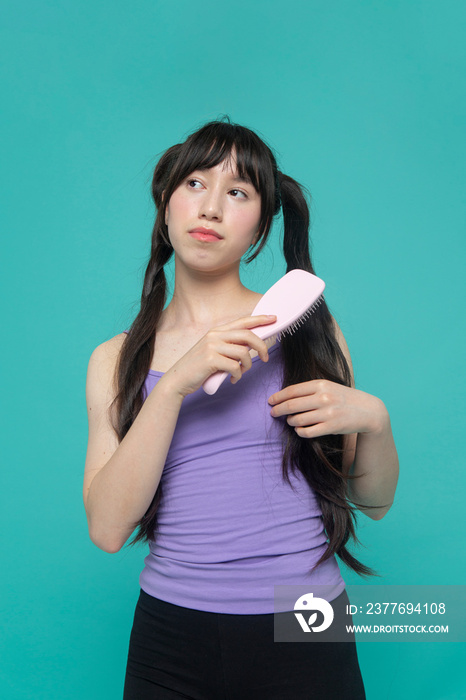 Studio shot of girl brushing hair