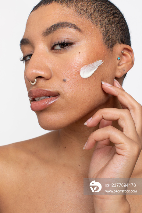 Studio portrait of woman face cream on cheek