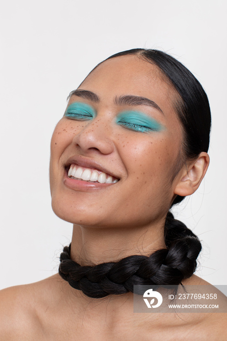 Portrait of smiling woman with black braid around neck