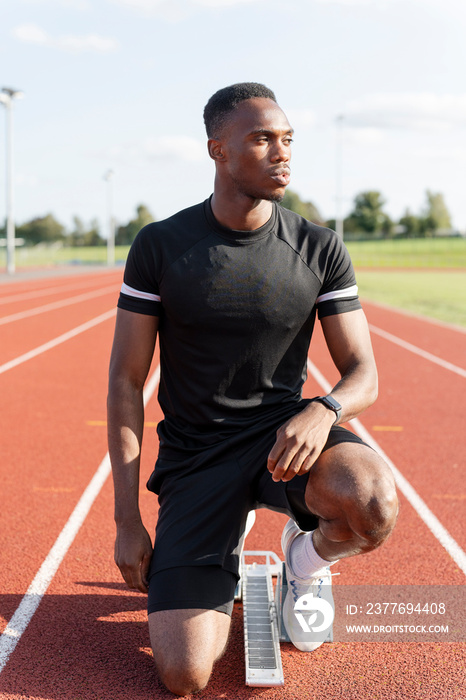 Athlete preparing to sprint at running track