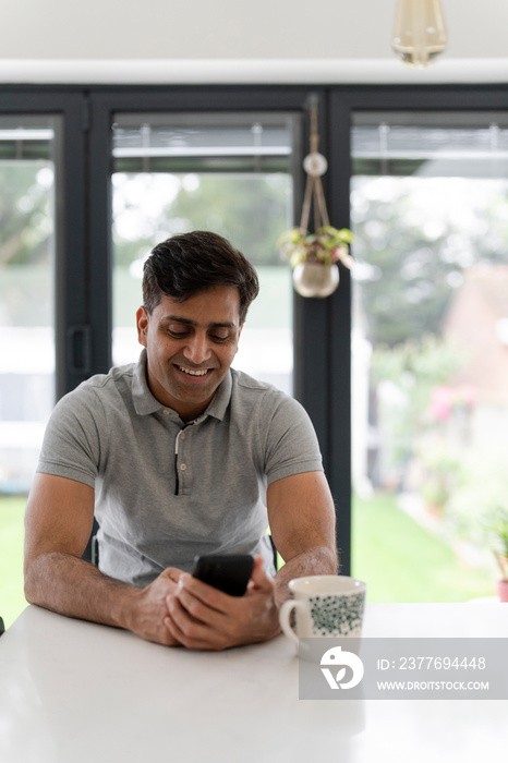 Man using phone while sitting at table