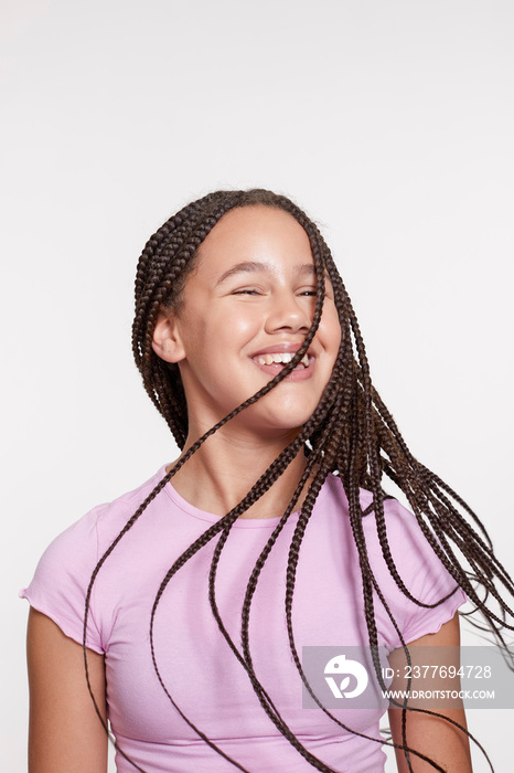 Studio portrait of smiling girl with long braided hair