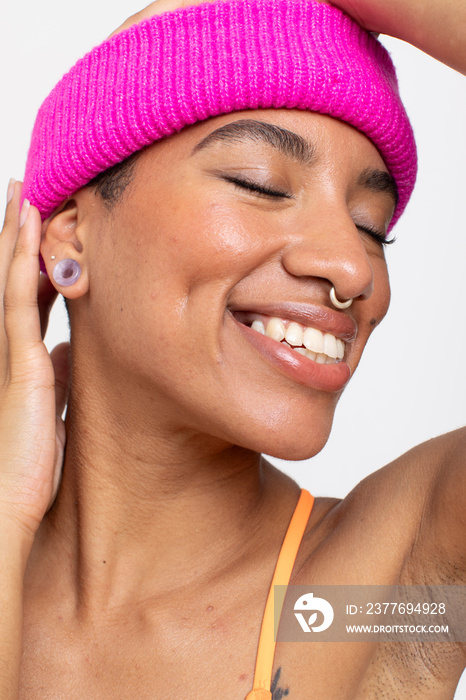 Studio portrait of smiling woman in pink woolen cap