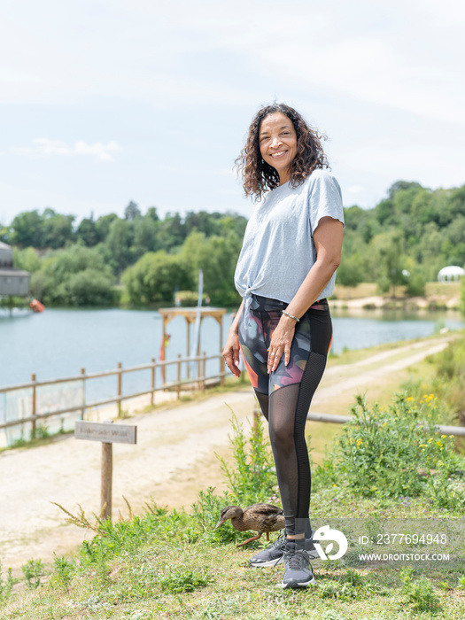 Portrait of smiling woman standing by lake