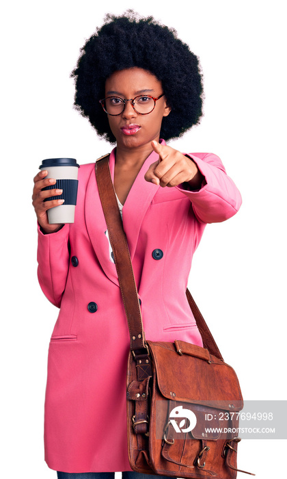 Young african american woman wearing leather bag and drinking a take away cup of coffee pointing with finger to the camera and to you, confident gesture looking serious