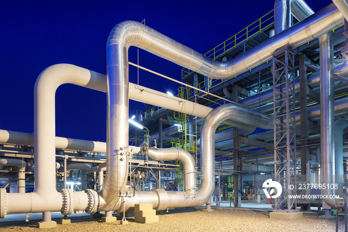 View of a gas refinery plant illuminated at dusk.