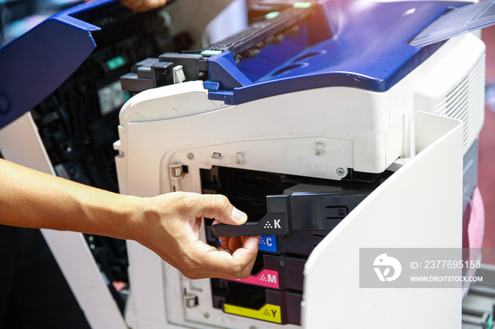 Technician hand open cover photocopier or photocopy to fix paper jam and replace ink cartridges for scanning fax or copy document in office workplace.