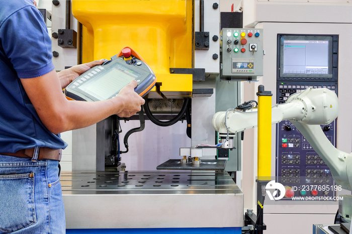 Engineer using wireless remote for control industrial robot