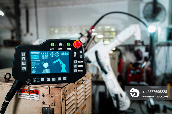 Robotic arm and its controller adept panel in a factory workshop . Industry robot programming software for automated manufacturing .