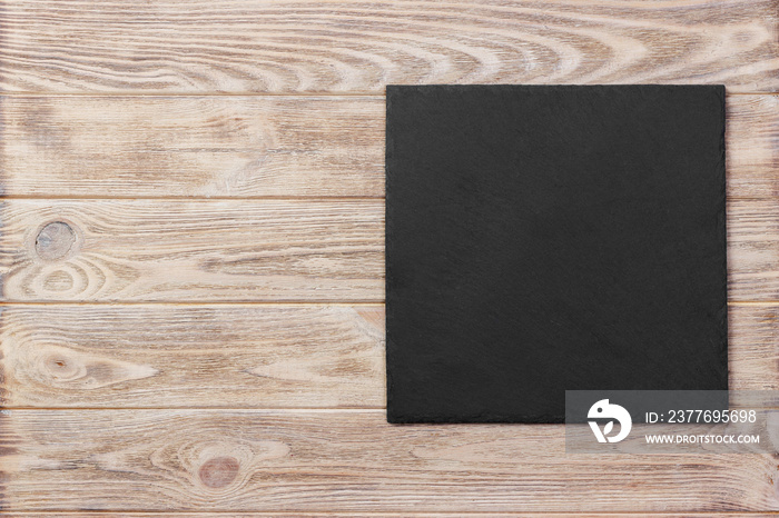 Slate blackboard on wooden table on wooden background