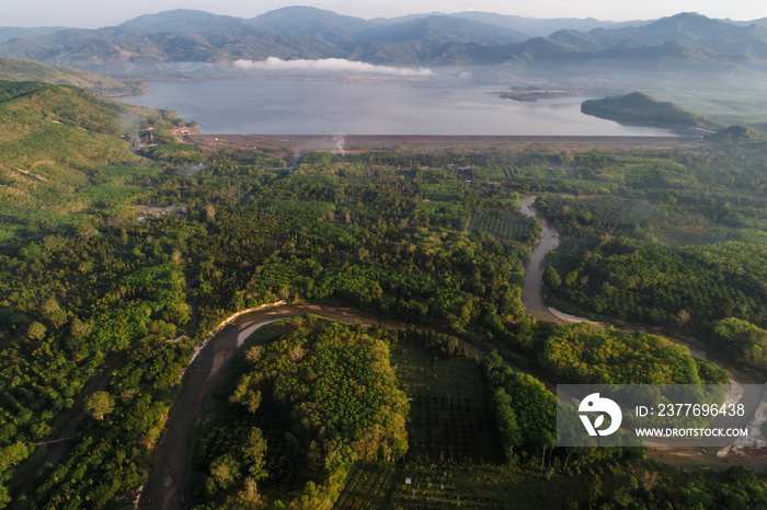 Aerial view of rural village with dam and river green forest