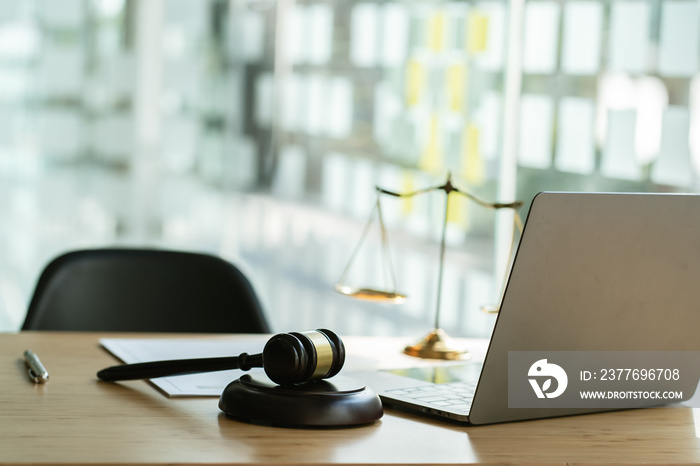 Scales of justice and Gavel on wooden table and Lawyer or Judge working with agreement in Courtroom, Justice and Law concept.