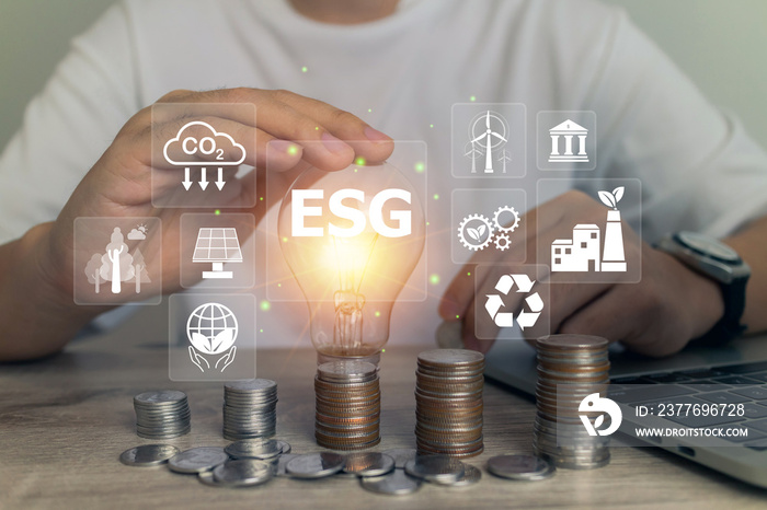 ESG environmental icon and Innovation through ideas and inspiration ideas concept.Person hand holding light bulb to illuminate for starting new idea to investment environment reduce CO2.