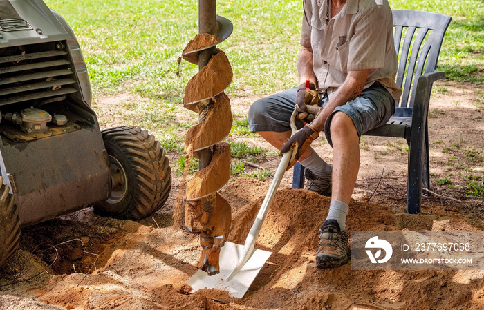 A Mechanical Auger Digging A Post Hole