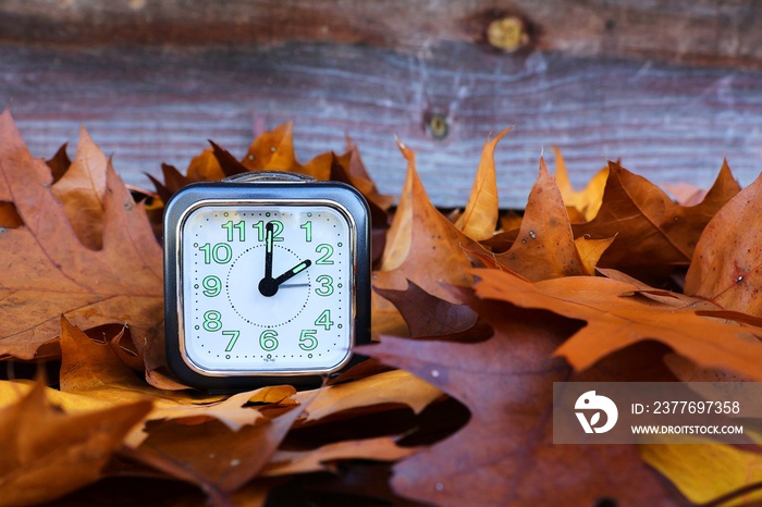 Clock with autumn leaves. Winter hour. 3 o’clock becomes 2 o’clock.