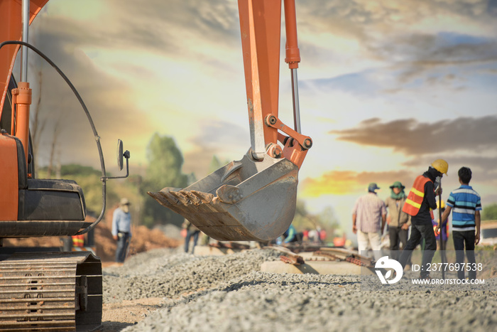 Back hoe and blurred construction worker in safety uniform in railway construction,construction site background