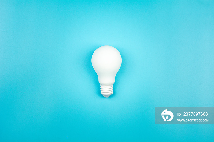 white light bulb is shine on blue table. - business growth and great ideas concept.