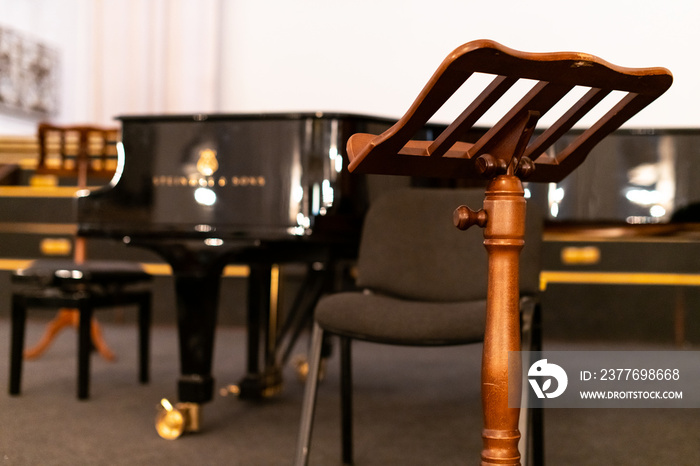 Music stand for paper sheets of music and piano. Before concert in cathedral. Heavy wooden music stand.