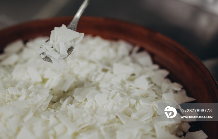 Close up of white soy wax flakes for candle making. Light texture of soy wax flakes. Ingredient for homemade candles. Ecological lifestyle