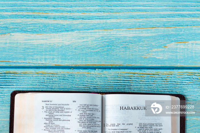 Habakkuk open Holy Bible Book on a rustic wooden background with copy space. Top table view. Old Testament Scripture prophecy study, Christian biblical concept.