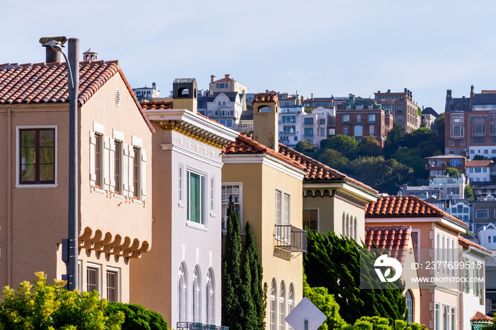 Row of colorful houses in the Marina District residential neighborhood; Pacific Heights residential district visible in the background; San Francisco, California