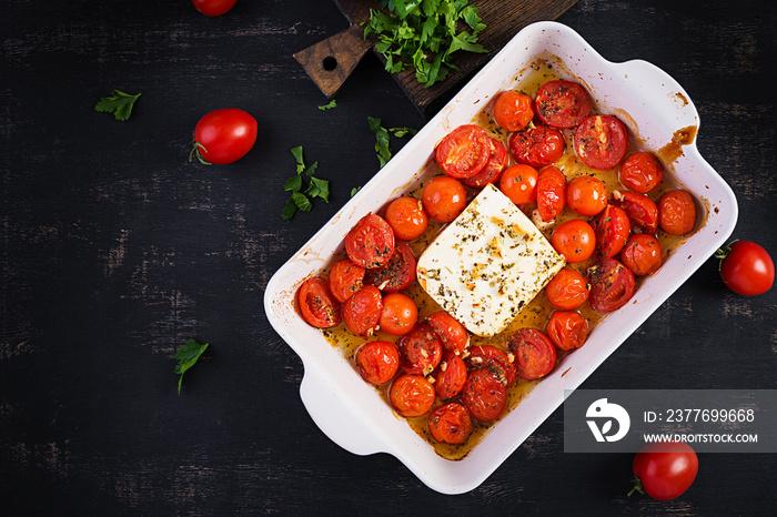 Fetapasta. Trending viral Feta bake pasta recipe made of cherry tomatoes, feta cheese, garlic and herbs in a casserole dish. Top view, above, copy space.