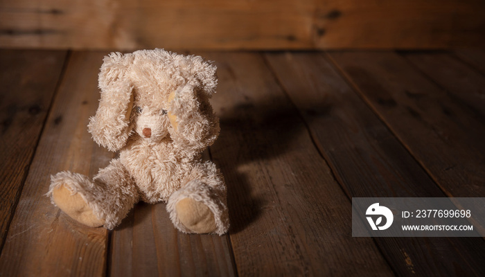 Child abuse.Teddy bear covering eyes, dark empty background, copy space