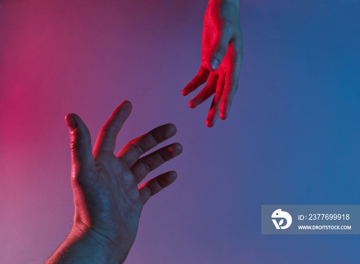 Two hands reach out to each other with a red-blue neon light. Minimalism fashion. Surrealism. Concept art