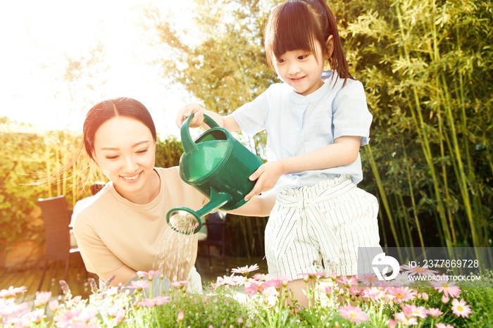 年轻的母亲和女儿在浇花